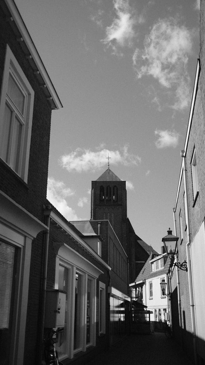 Black and white photo of historic buildings and church tower in Sluis, Netherlands.