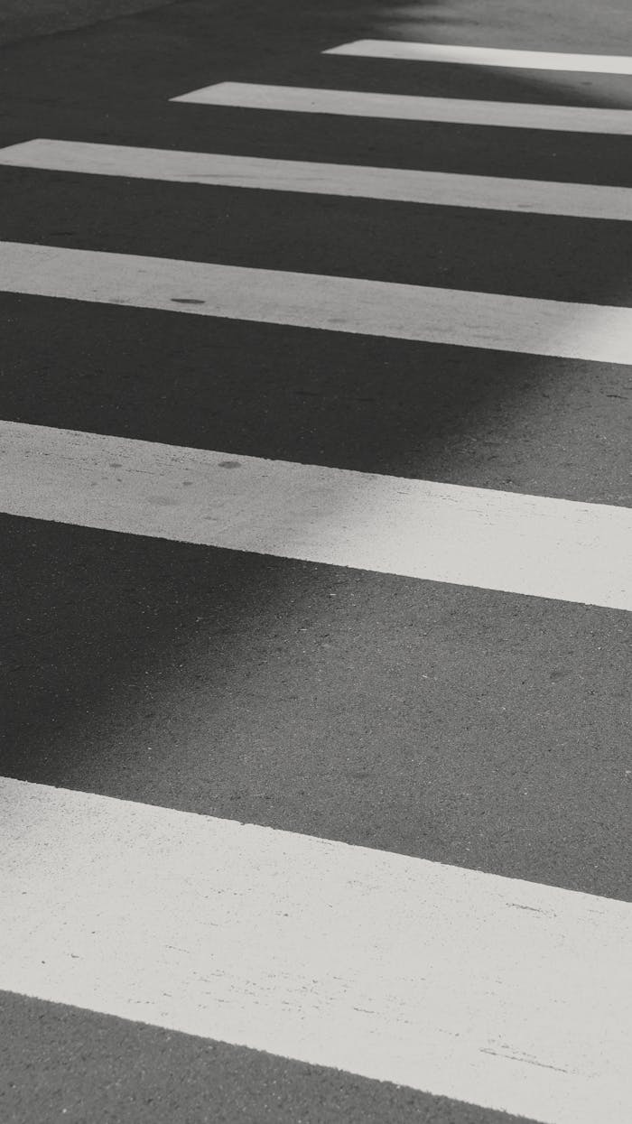 Black and white photo of a zebra crosswalk with shadow play, taken in Taiwan.