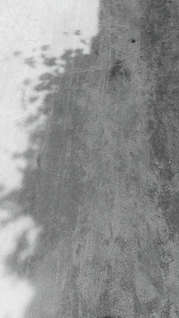 Minimalist abstract photograph capturing shadows on a concrete surface, evoking tranquility.